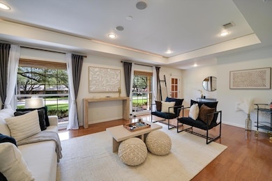 Living area featuring a tray ceiling, wood finish