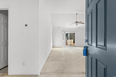 Carpeted entryway with ceiling fan