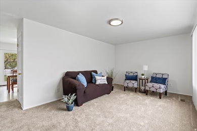 Living area featuring NEW carpet & pad. NEW windows throughout