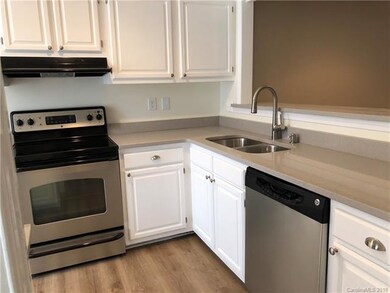 Kitchen has gray quartz countertops, stainless app