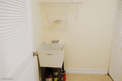 Clothes washing area with baseboards, a sink, and
