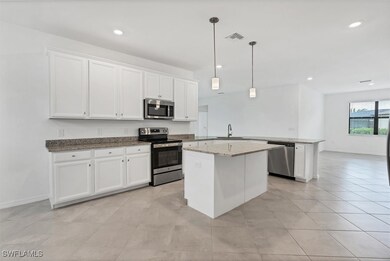 Kitchen featuring a sink, white cabinets, a penins