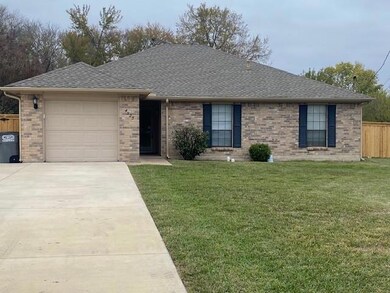 Ranch-style home featuring a garage and a front lawn