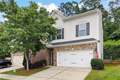 View of front of home featuring driveway, a garage, and brick siding