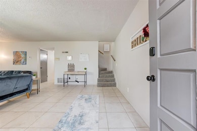 Foyer featuring light tile floors and a textured c