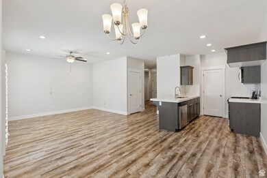Kitchen featuring recessed lighting, light wood-type flooring, open floor plan, decorative light fixtures, and a chandelier