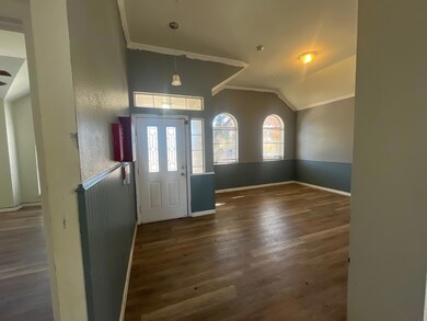 Entryway with crown molding, dark wood-type floori