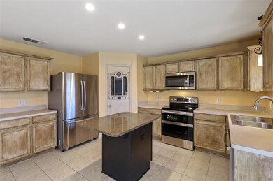 Stainless appliances and an island to prepare your