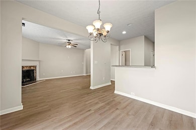 Unfurnished living room featuring baseboards, a te