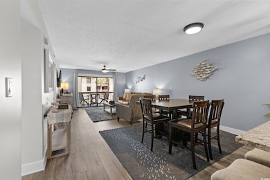 Dining room featuring ceiling fan, wood finished floors, and a textured ceiling