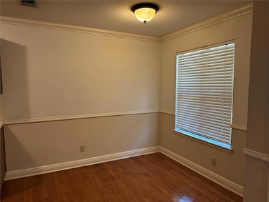 Unfurnished room with ornamental molding and dark wood-style floors