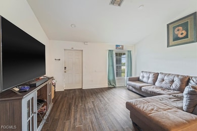 Living area featuring dark wood finished floors and baseboards