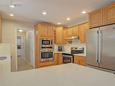 Stainless steel appliances...glimpse of walk-in pantry to the back.. Door on right leads to the garage.
