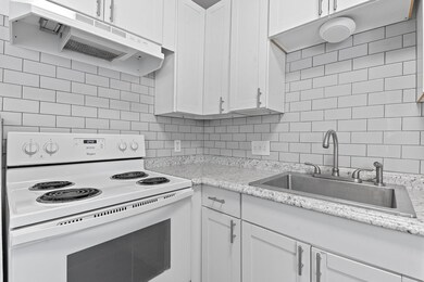 Kitchen with white range with electric stovetop, 