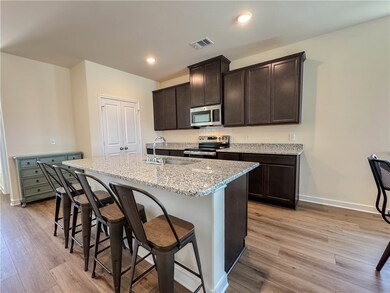 Kitchen featuring a center island with sink, visib