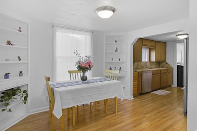 Dining room featuring built in shelves, light wood finished floors, and arched walkways