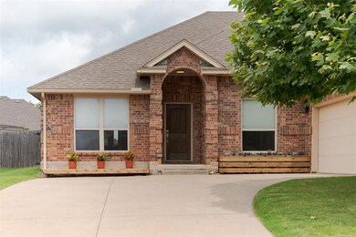 View of front of home featuring brick siding and roof with shingles
