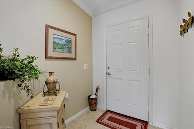 Entrance foyer featuring crown molding and light tile patterned flooring