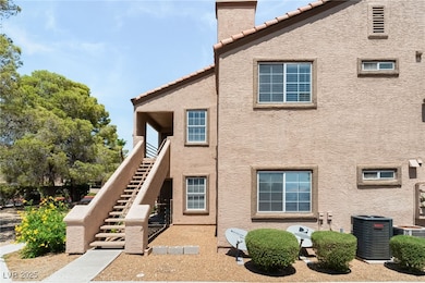 Rear view of house featuring a tile roof, stucco siding, stairway, and a chimney