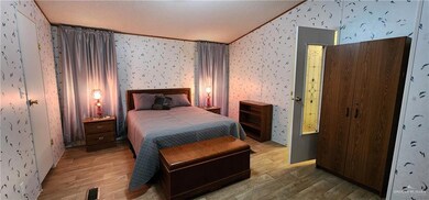 Bedroom with crown molding, light hardwood / wood-style floors, and a textured ceiling