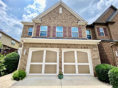 View of front of house with a garage, driveway, and brick siding