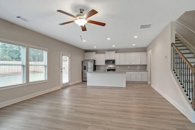 Kitchen featuring a center island with sink, light