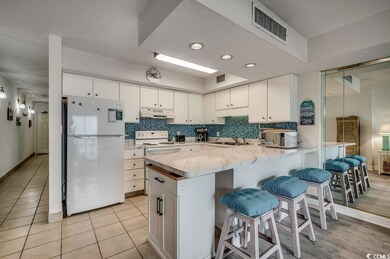 Kitchen with white cabinets, a kitchen bar, and wh