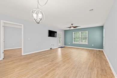 Unfurnished room with a chandelier, a ceiling fan, light wood-style floors, and baseboards