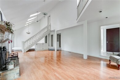 Living area with a towering ceiling, stairway, lig