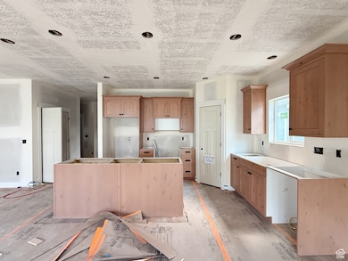 Kitchen featuring a center island, recessed lighting, and light brown cabinetry