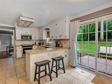 Eat-in area of kitchen with replaced sliding doors to large rear deck! A perfect set up for entertaining friends.