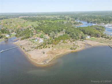 Birds eye view of property featuring a water view and a view of trees