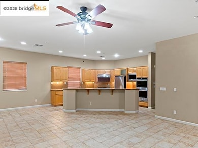 Kitchen with a breakfast bar, tasteful backsplash, a large island, ceiling fan, and recessed lighting