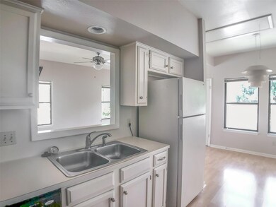 Kitchen with light countertops, a sink, plenty of