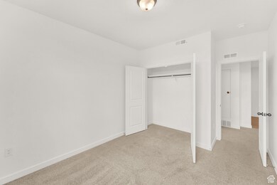 Unfurnished bedroom with light colored carpet and a closet