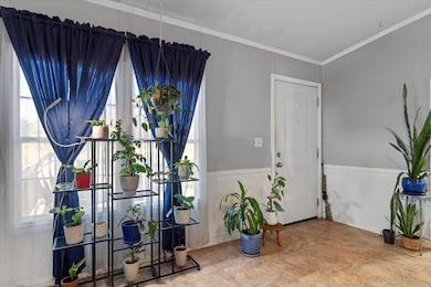 Foyer entrance featuring crown molding and wainscoting