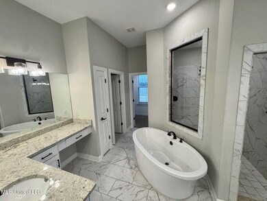 Bathroom featuring vanity, a soaking tub, visible 