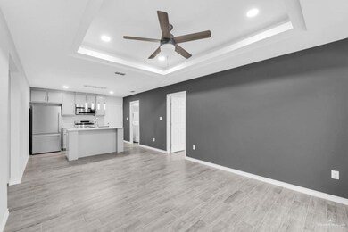 Unfurnished living room featuring a tray ceiling, recessed lighting, light wood-type flooring, and ceiling fan