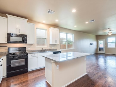 Kitchen featuring black appliances, open floor pl