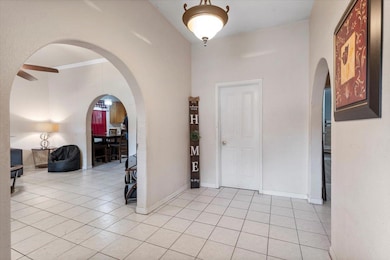 Entrance foyer with arched walkways, light tile p