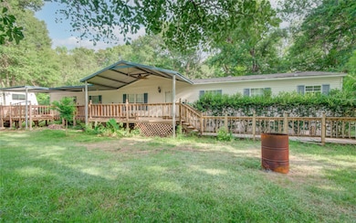 A long and spacious deck runs along the front facade, continuing down onto wooden rails below, beautifully framing the home.
