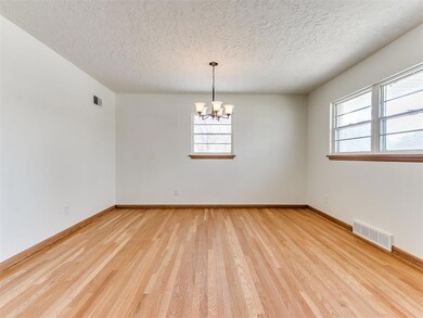 Spare room with an inviting chandelier, a textured