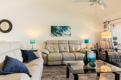 Dining area with dark hardwood / wood-style floors, high vaulted ceiling, and ceiling fan