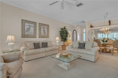 Living room featuring carpet, crown molding, a cha