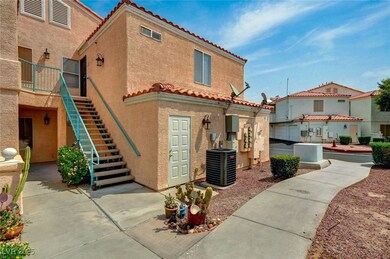 Back of property with a tile roof, stucco siding, and stairway