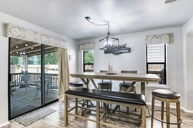 Dining area with wood finished floors, a chandeli