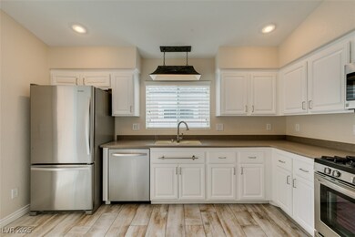 Kitchen with light wood-style tile flooring, white