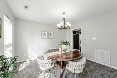 Dining area with carpet, visible vents, and an inv