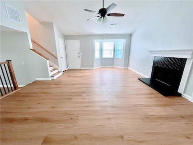Unfurnished living room featuring stairs, light wo