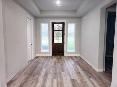 Entryway features a wooden front door with glass p